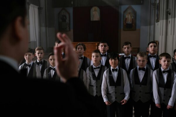 Man Conducting a Choir of Boys in a Church